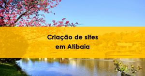 Vista do lago do Major em Atibaia com reflexo de árvores e prédios na água, céu azul e uma árvore com flores rosas à esquerda. Texto promocional sobre criação de sites na cidade.